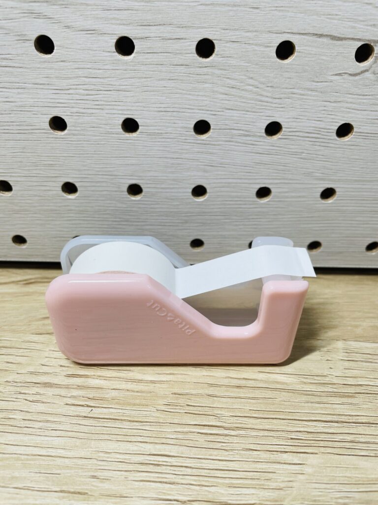 ピンク色のテープカッターにセットされた白いテープ