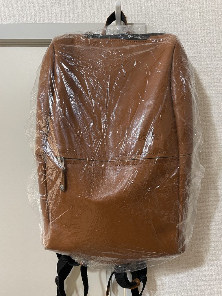 ダイソーのレインバッグカバーを本革リュックに装着した前面の様子