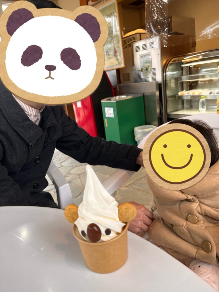 カフェのテーブルでソフトクリームを前に並ぶ父と子ども