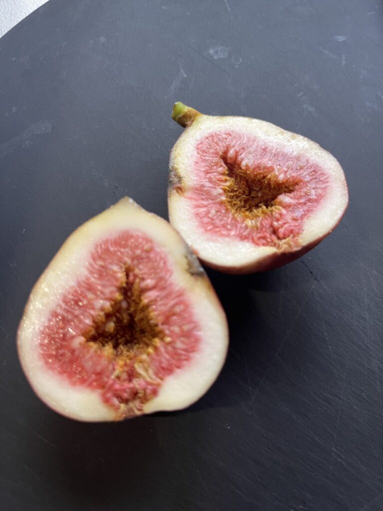 半分に切った熟したイチジク。赤い果肉と白い果皮のコントラストが鮮やかに写っている