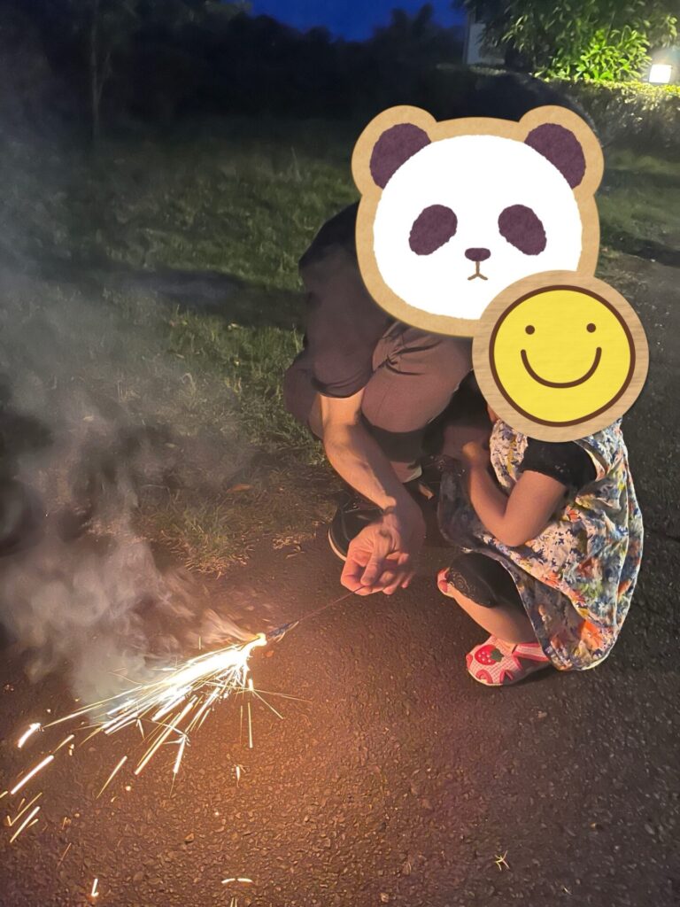 ホテル前の指定スペースで花火を楽しむ様子。大人と子どもがしゃがんで手持ち花火をしている。