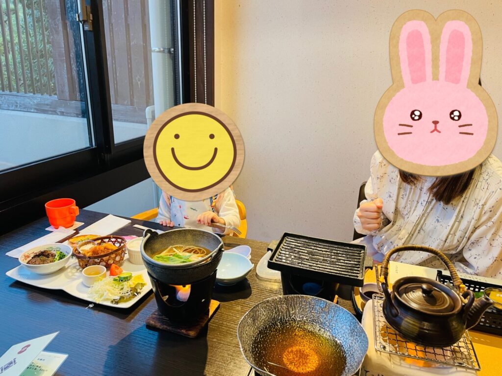 ホテルの宴会場で提供されたお子様ランチとうどんを前に食事する子ども