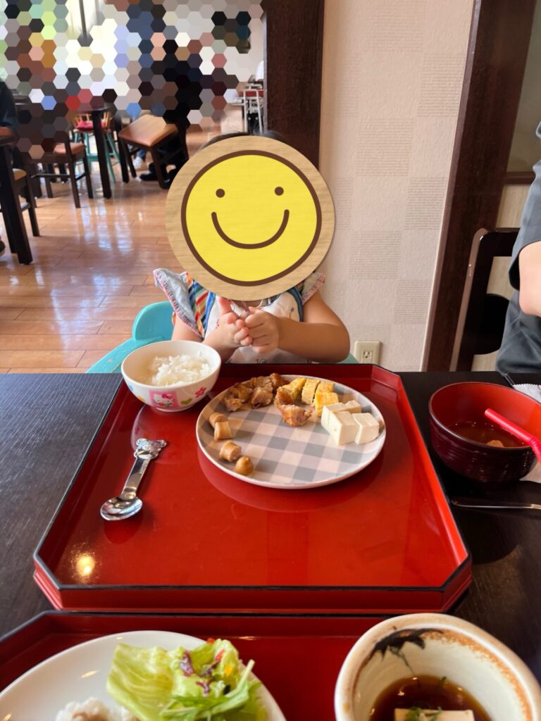 朝食バイキングで子ども用の料理を前に座っている様子