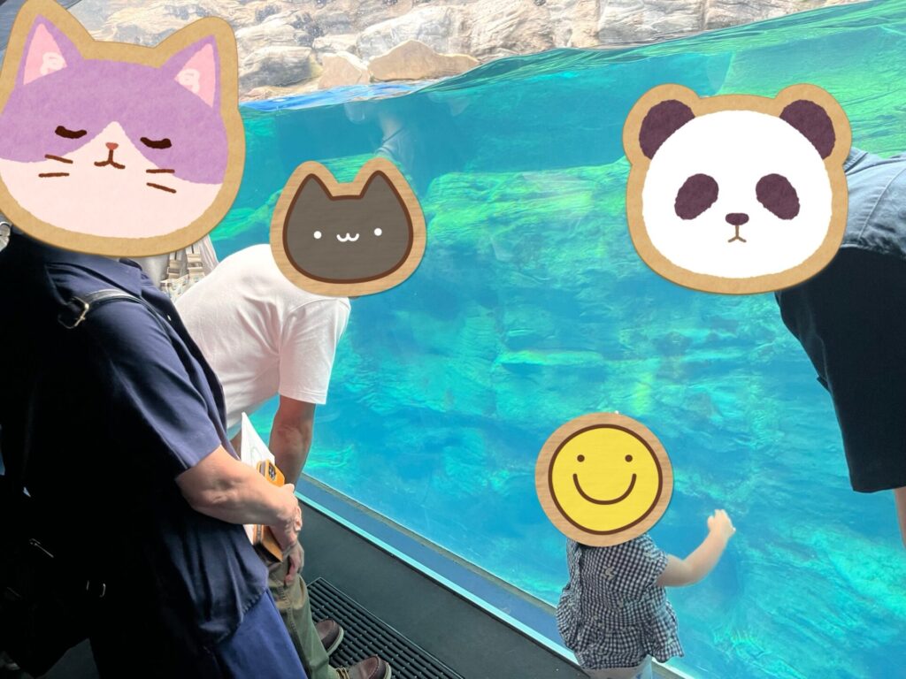 水族館の大きな水槽前で、子どもが水槽の魚を見上げている場面