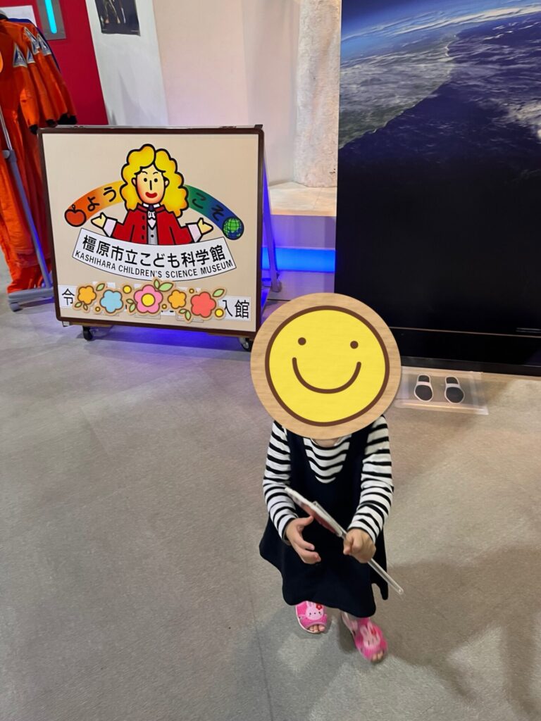 橿原市子ども科学館の入口で、娘が看板の前に立っている様子