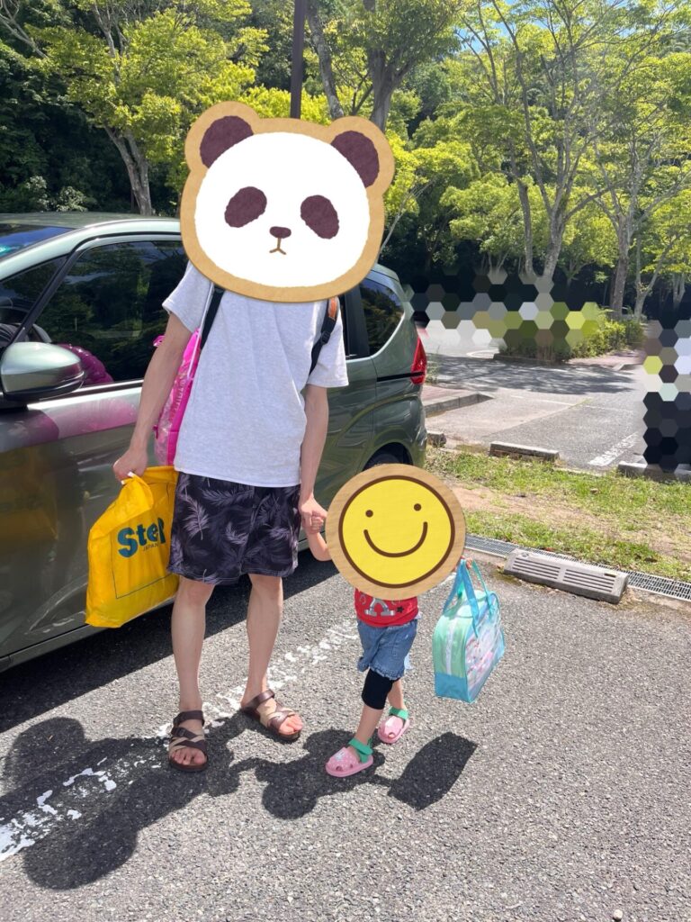 神戸しあわせの村の駐車場で、プールバッグを持って歩く親子