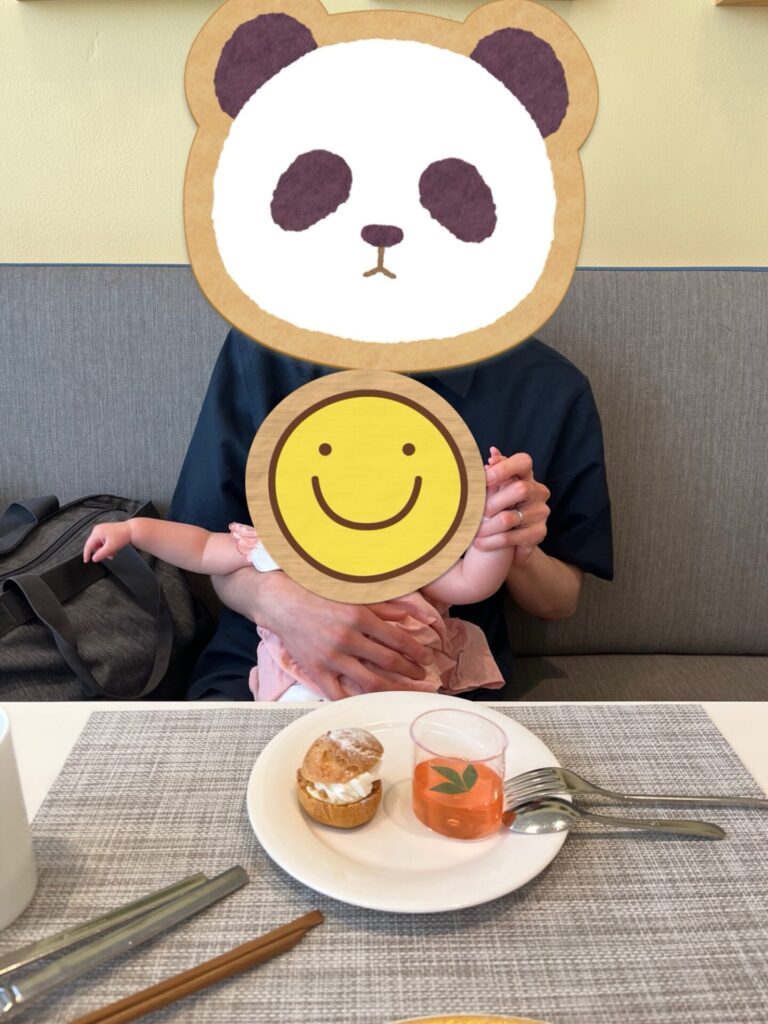カフェのテーブルでデザートを前に子どもを抱っこする男性
