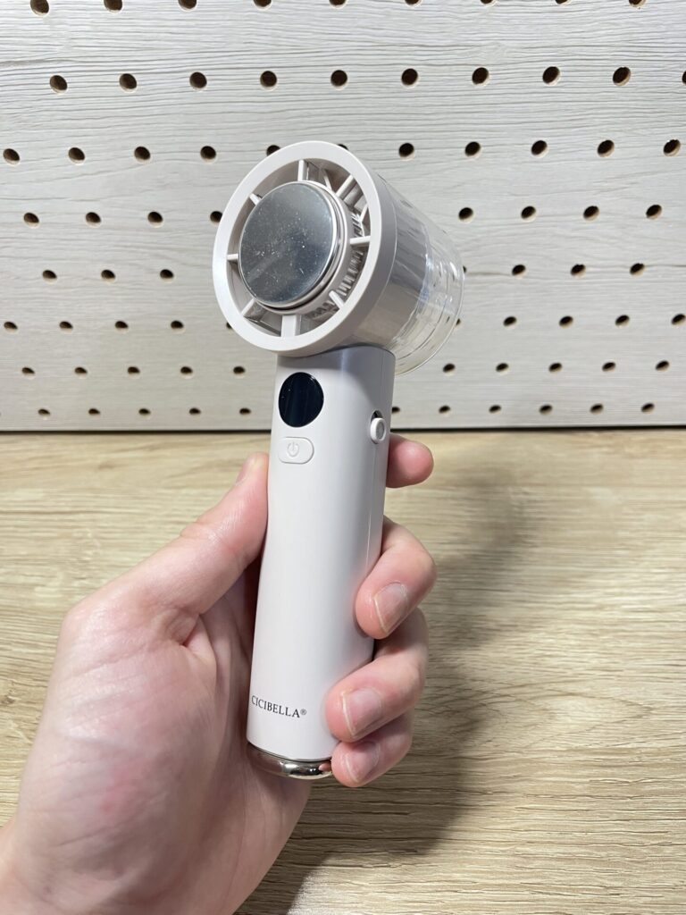 CICIBELLA冷却ハンディファンPROMAX本体を手に持った様子。淡いグレーカラーのコンパクトなデザイン。