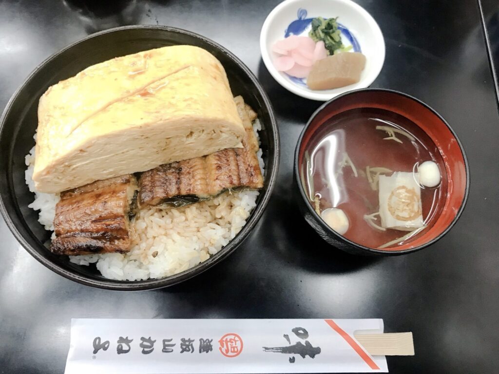 厚焼き卵と鰻の蒲焼きがのった逢坂山かねよの名物きんし丼と吸い物、小鉢のセット。