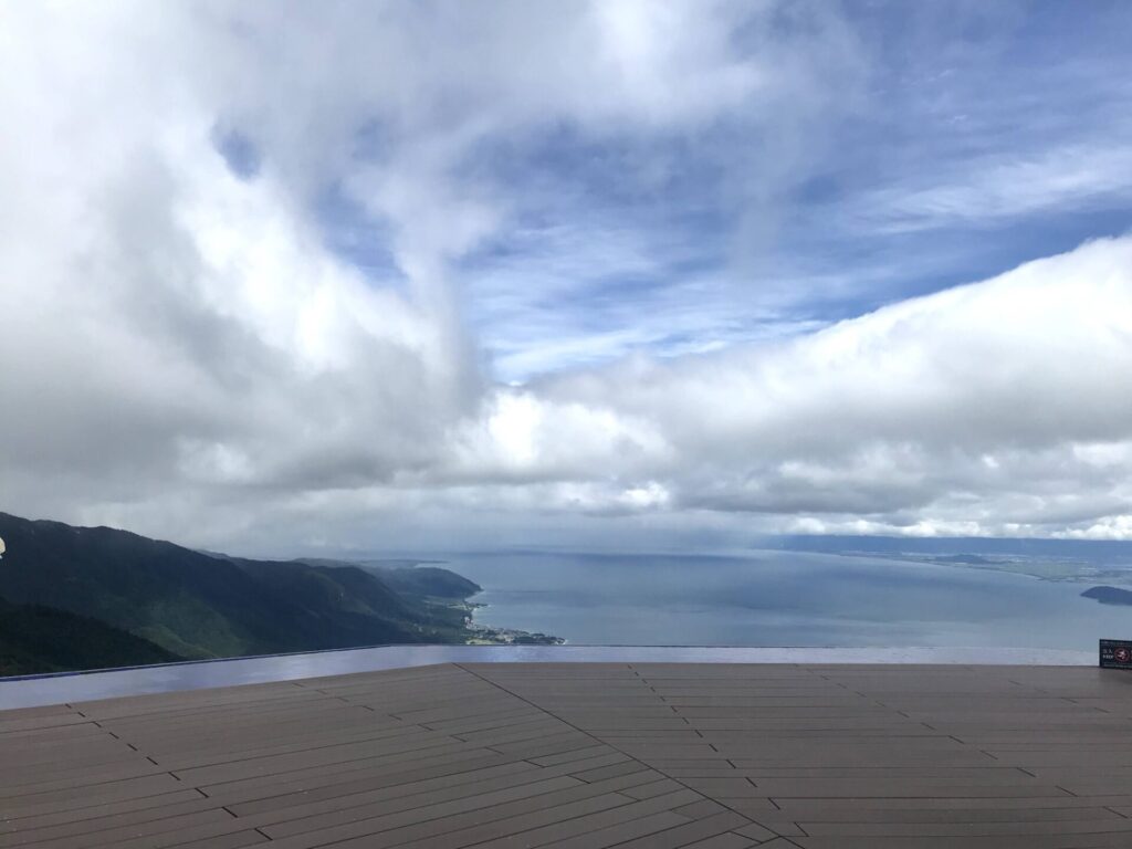 びわ湖バレイ山頂から望むびわ湖の景色。雲の切れ間から青空がのぞく。