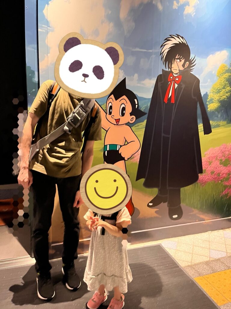 パソナパビリオンの壁画前で記念撮影する親子