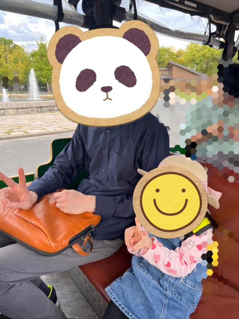 大阪城公園のロードトレインに乗っている親子
