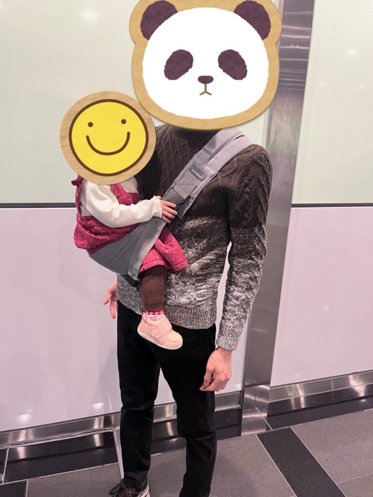 グスケットで短時間の抱っこをしている父と2歳の娘。両手が使えて便利。