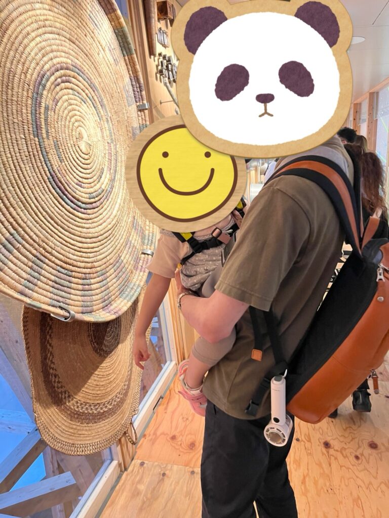 夫がレザーリュックとグスケットを併用して抱っこしている様子。リュックはシンプルで通勤にも使える。