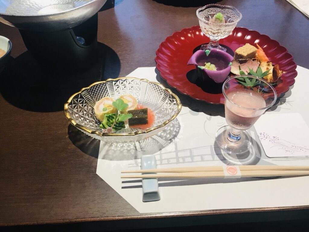宍道湖温泉なにわ一水の夕食、彩り豊かな前菜と食前酒が並ぶテーブル。
