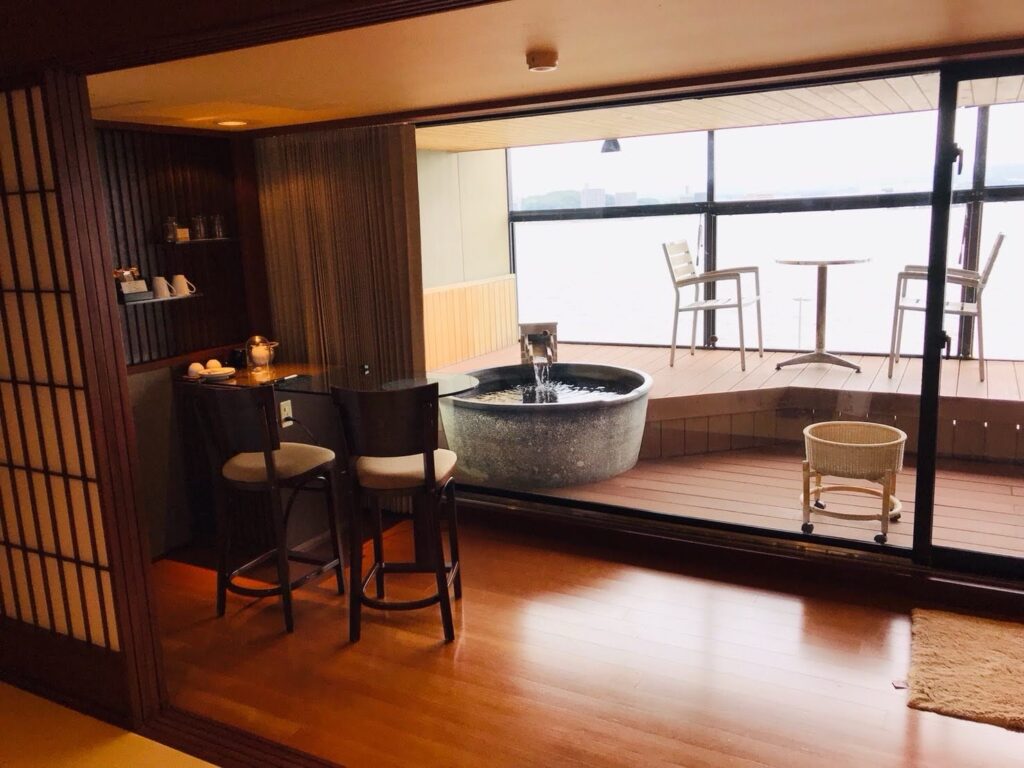 宍道湖温泉なにわ一水の客室。バーカウンターと露天風呂付きテラスが見える室内。
