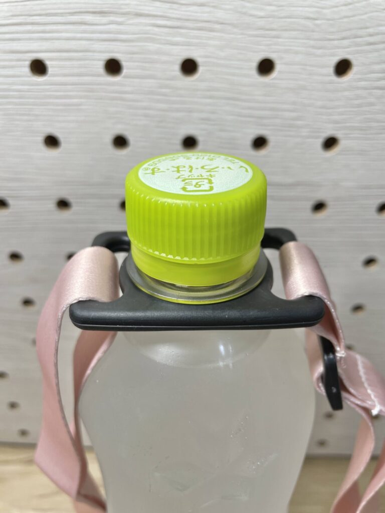 ペットボトルの首にストラップを取り付けた様子。持ち運びやすくそのまま飲める仕様。
