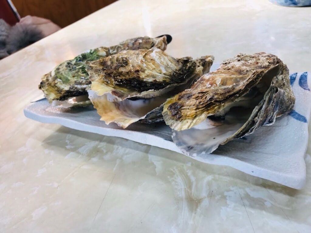 鳥羽の海辺の食堂で焼き牡蠣を撮影した写真。