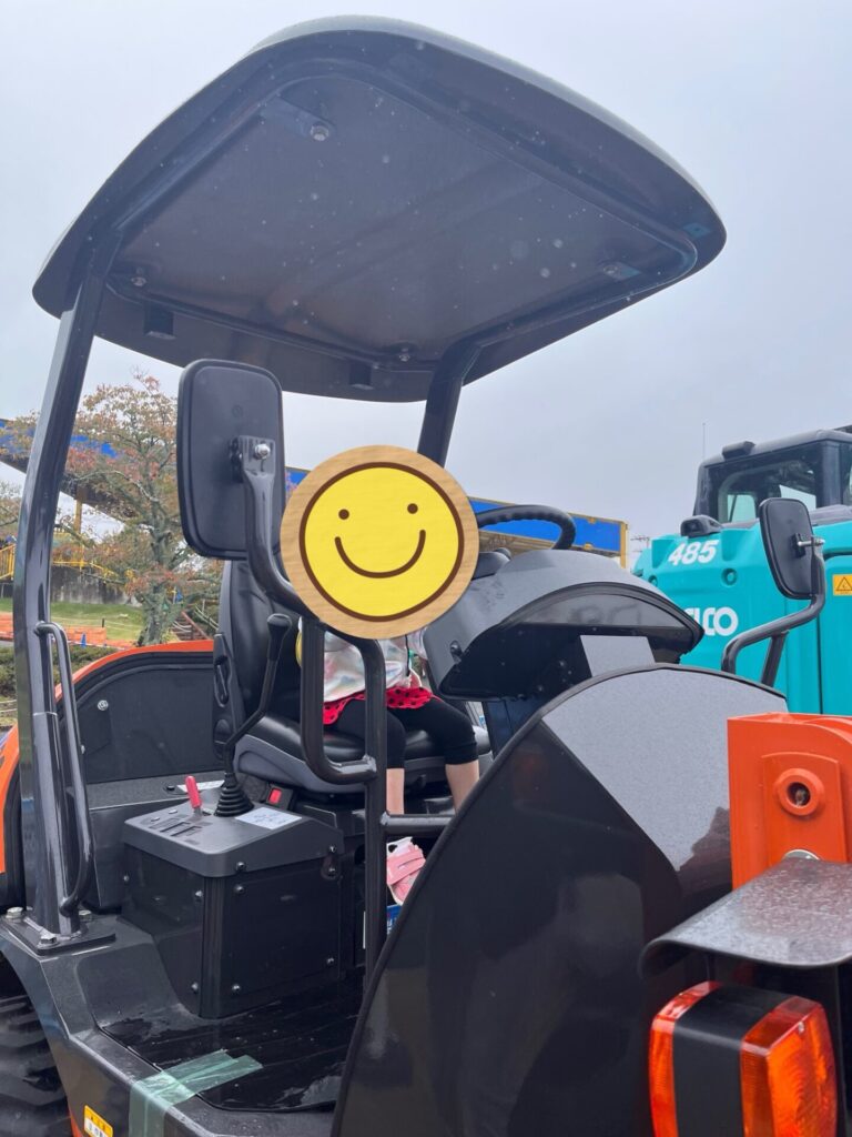 東条湖おもちゃ王国「はたらくくるま大集合」で、ホイールローダーに乗って運転席を体験する娘。