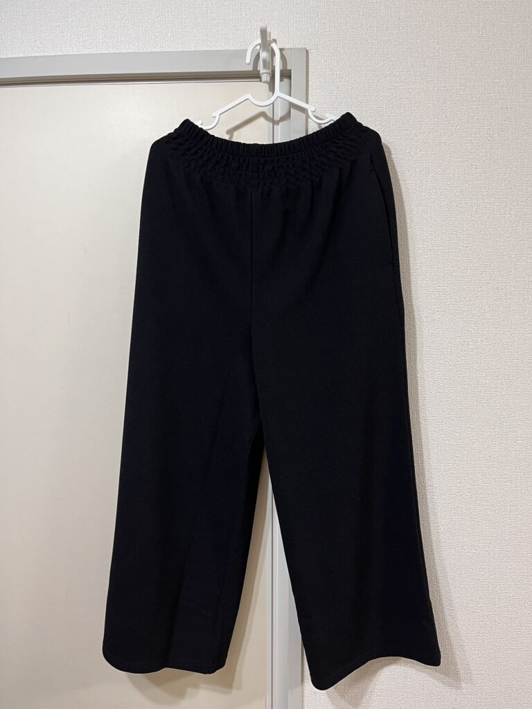 乾燥機OKのエンボス素材で作られたcocaの黒のワイドパンツ。軽くて動きやすく、在宅向きのシンプルデザイン。