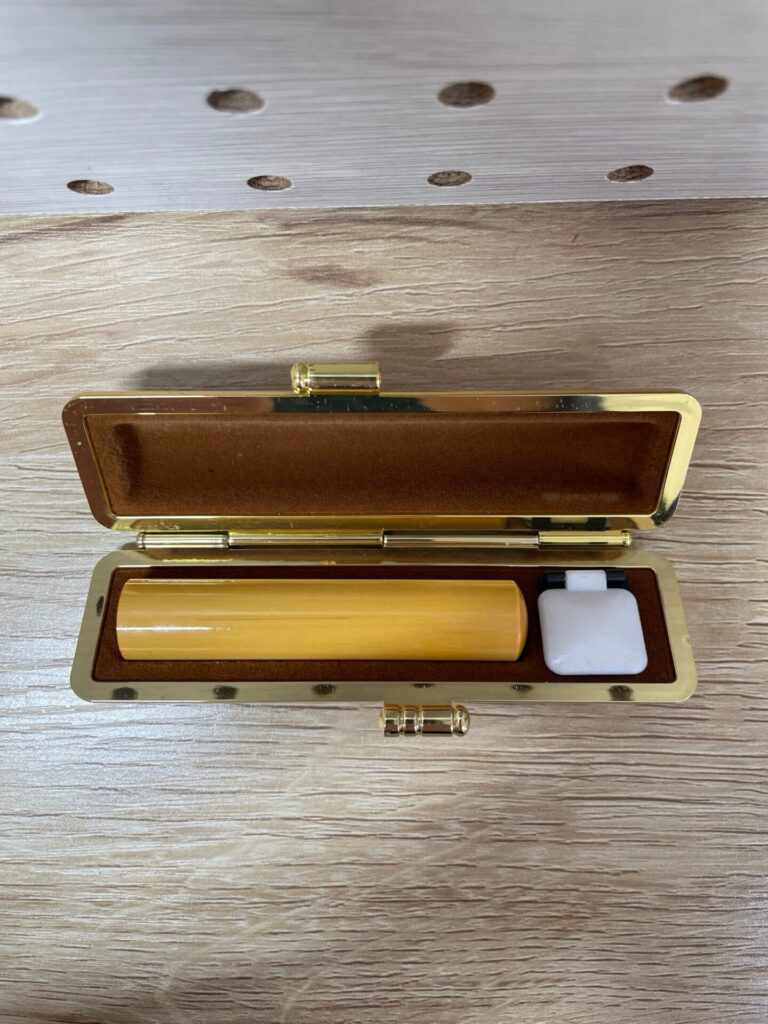 子どもの銀行印セット。ナチュラルカラーの印鑑と朱肉が入ったケースを開いた状態。