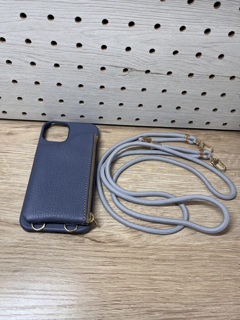 ストラップ付きのスマホケース本体と紐ストラップを並べて置いた写真。