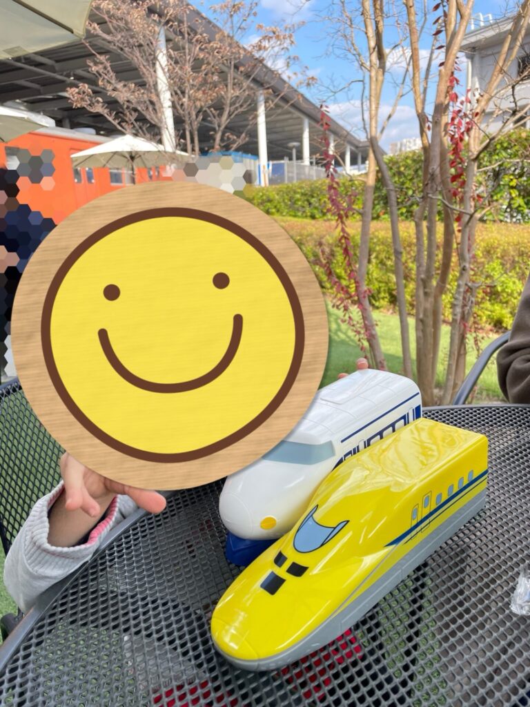 テラス席で子どもがお子様駅弁を手元に置いて食事の準備をしている様子。