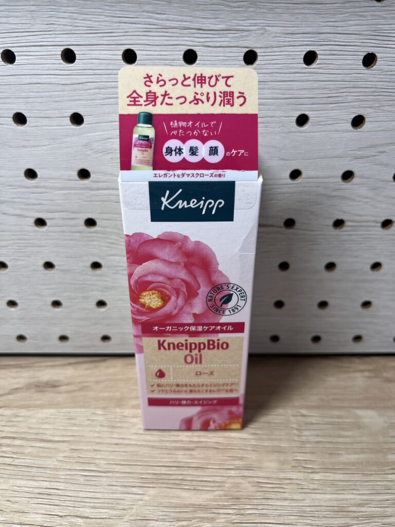 クナイプのビオオイル（ローズ）の箱が木目の台の上に置かれている。