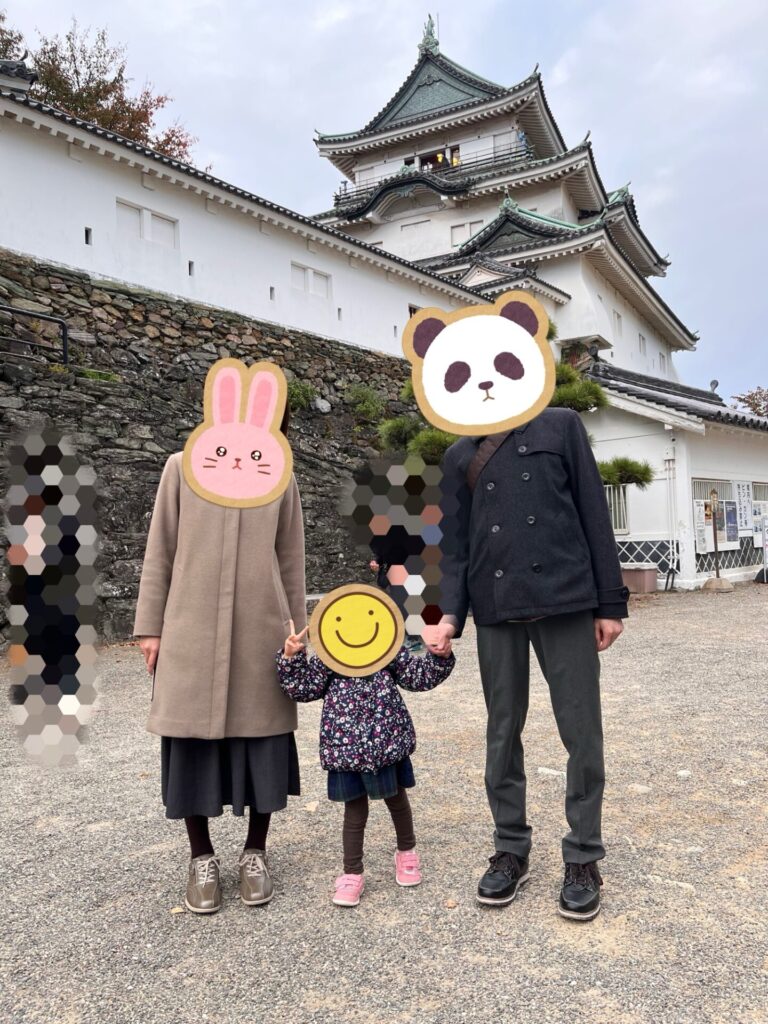 和歌山城の天守を背景に家族が並んで立っている様子