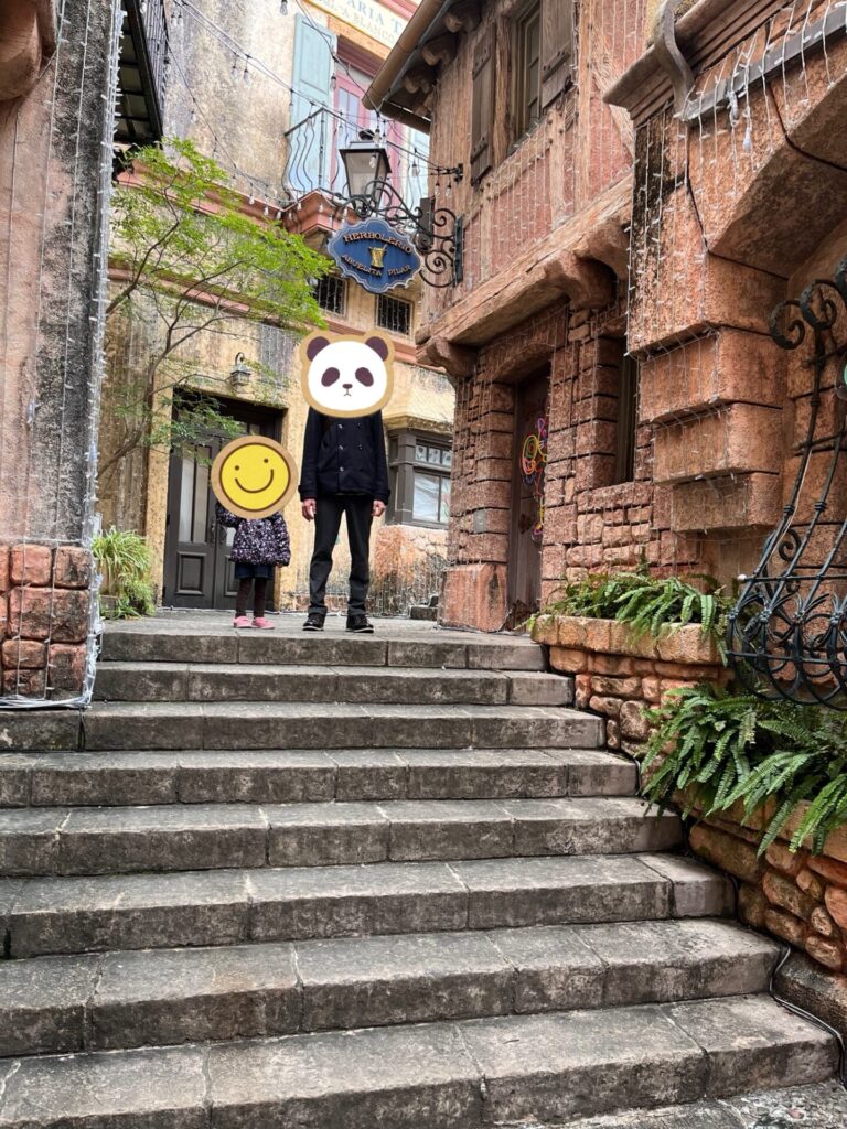 ポルトヨーロッパの石造りの階段とヨーロッパ風の建物を背景に家族が立っている様子