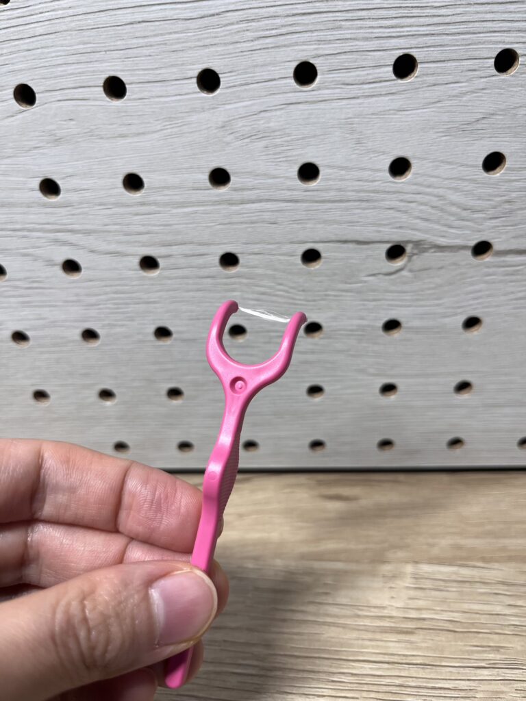 ピンク色のクリニカアドバンテージY字フロスを手に持った状態。