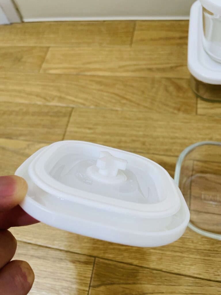 IWAKIの密封ガラス保存容器のフタ部分を手に持って写した写真。
