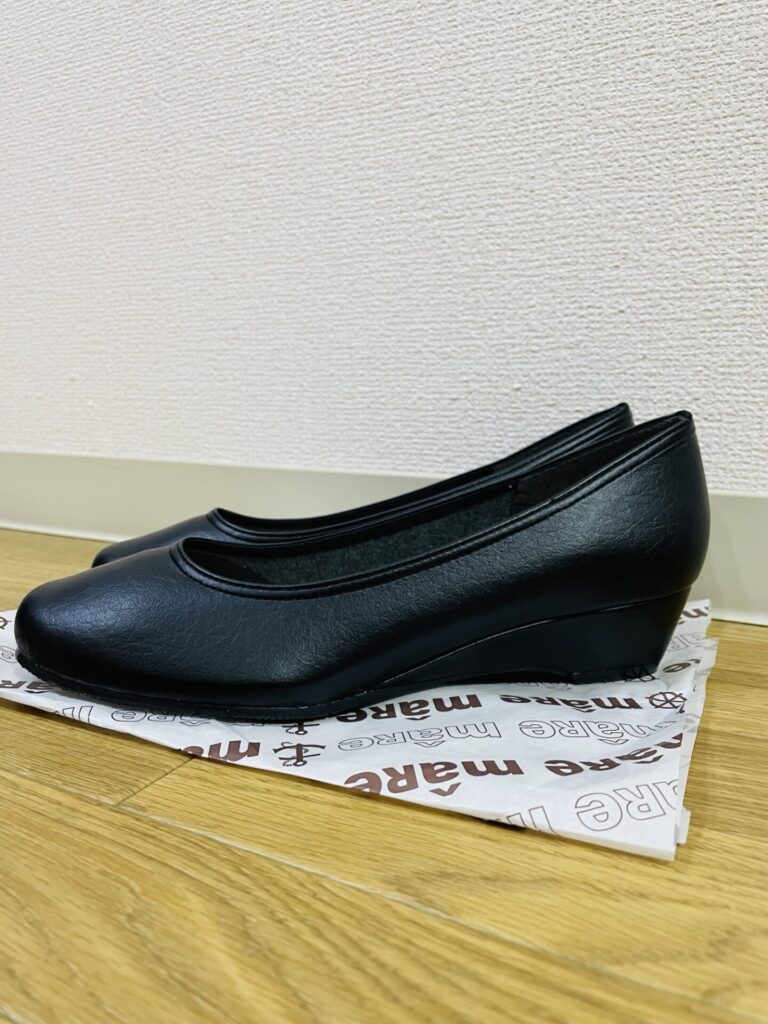 黒のウェッジパンプスを横から撮影し、ヒールの高さと形がわかるように写した写真。