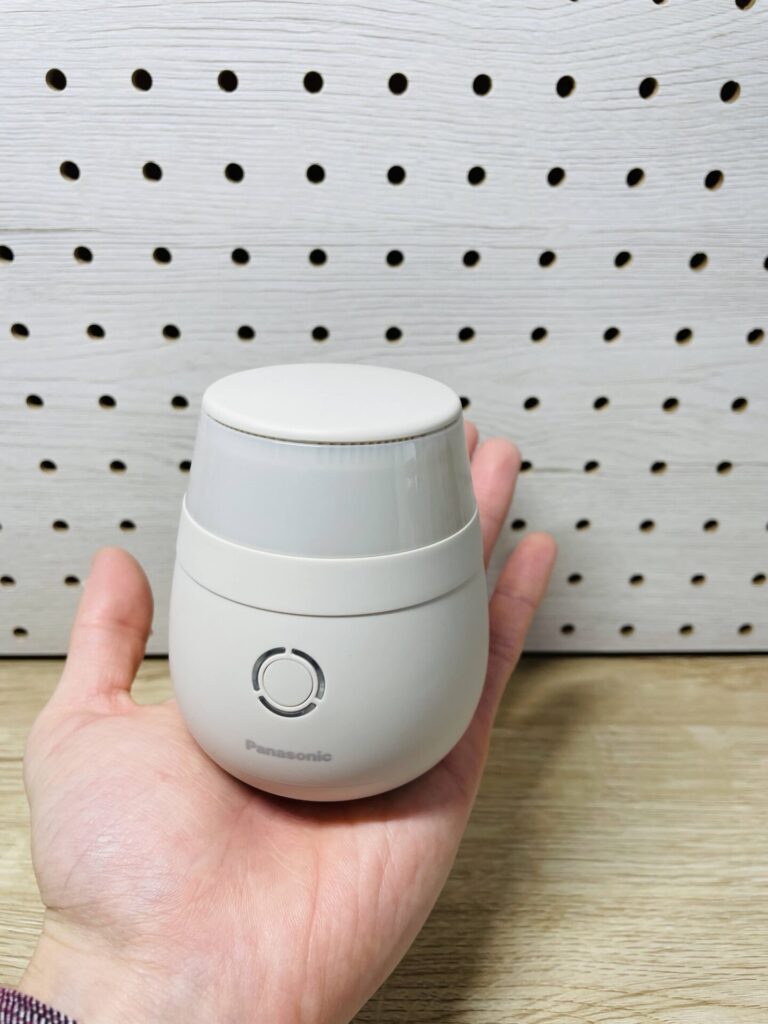 手のひらにパナソニックの毛玉クリーナー本体を乗せて大きさが分かるように写した写真。