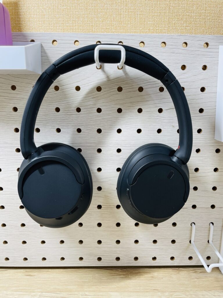 有孔ボードにフックで掛けて収納しているSONY WH-CH720Nの写真。