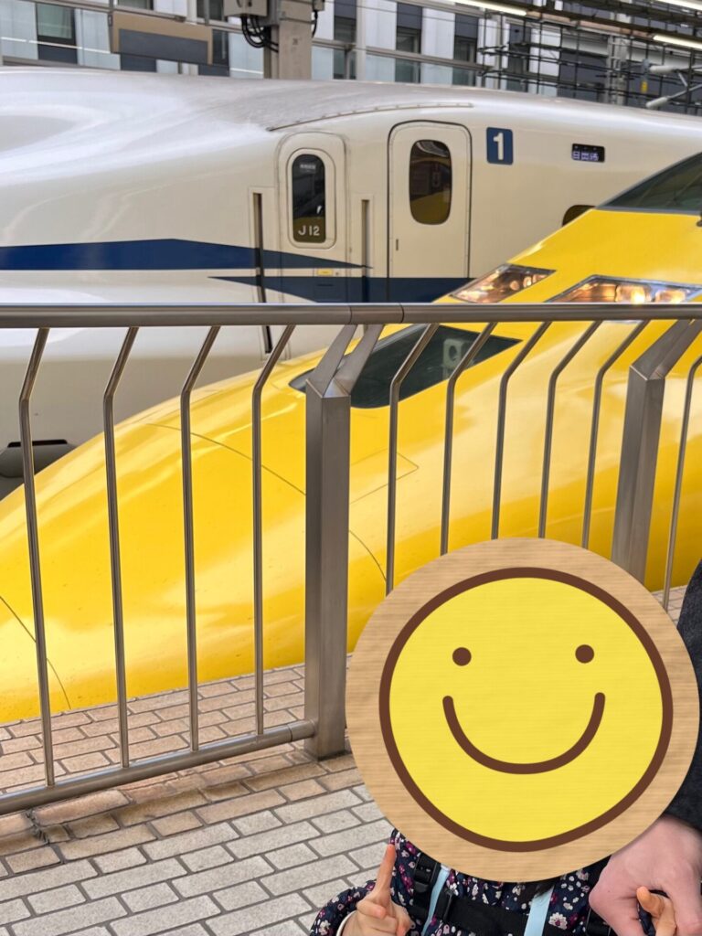 京都駅の新幹線ホームでドクターイエローと新幹線車両が並んで停車している様子。