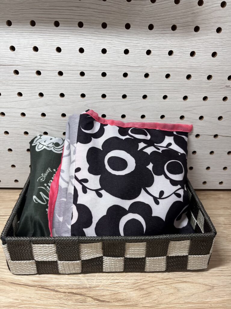 玄関の棚に置いたかごにエコバッグを収納している様子。