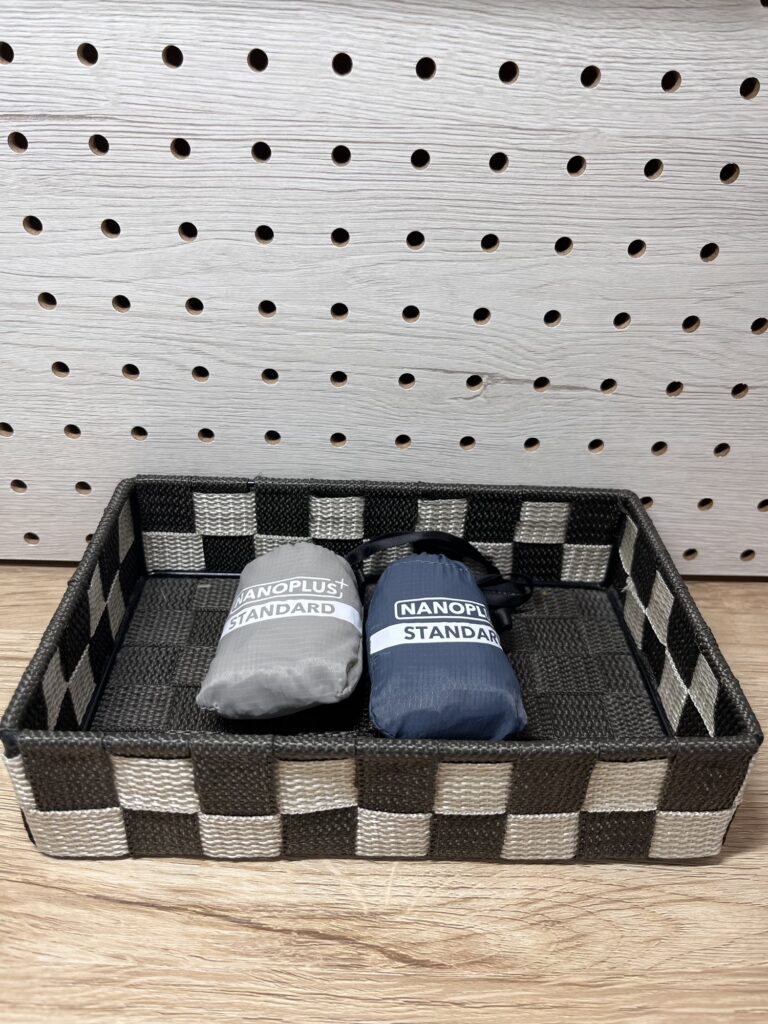 玄関の収納かごにNANOPLUSスタンダードサイズのエコバッグを2つ入れている様子。