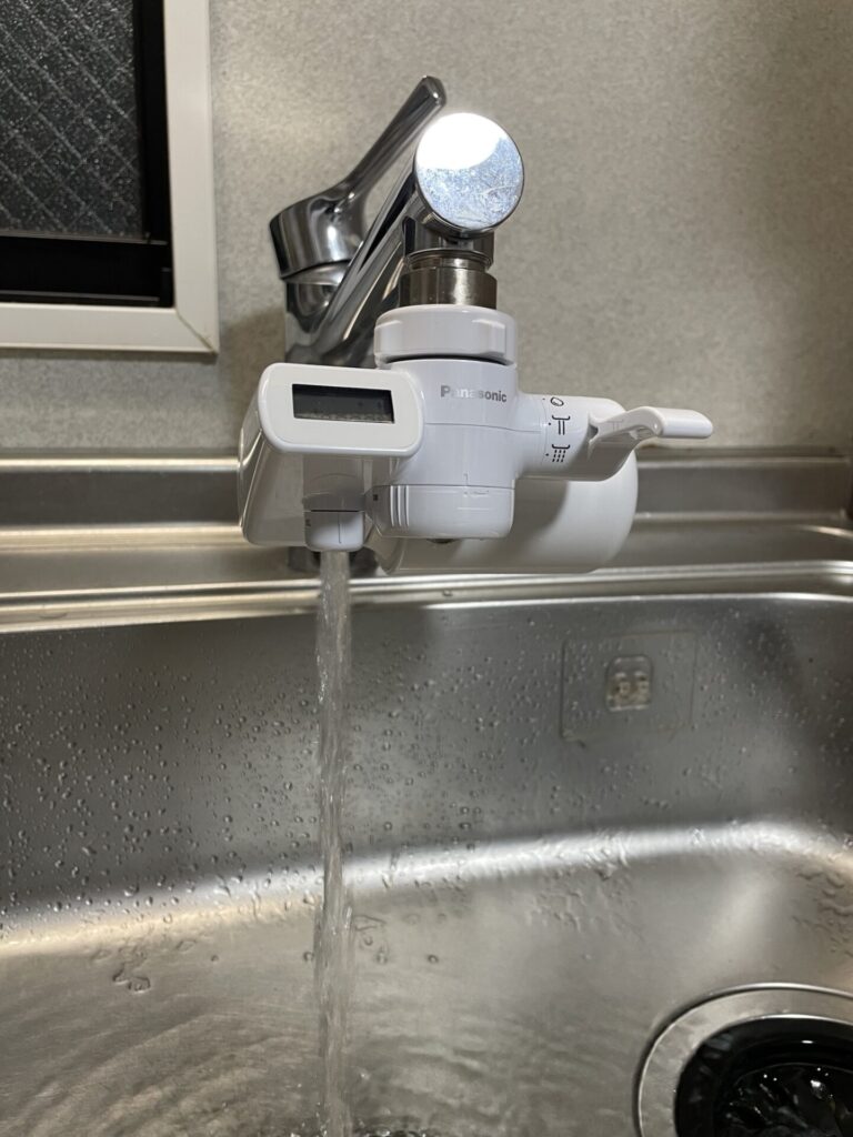 パナソニックの浄水器を蛇口に取り付けた状態で水を出している様子。