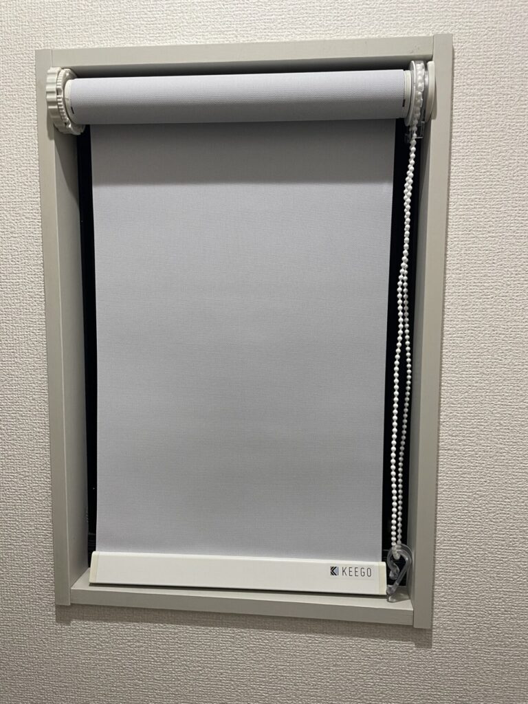 窓枠内につっぱり式で設置したトイレのロールカーテン。