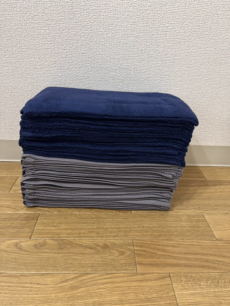 ネイビーとダークグレーのフェイスタオルを20枚まとめて入れ替えた様子