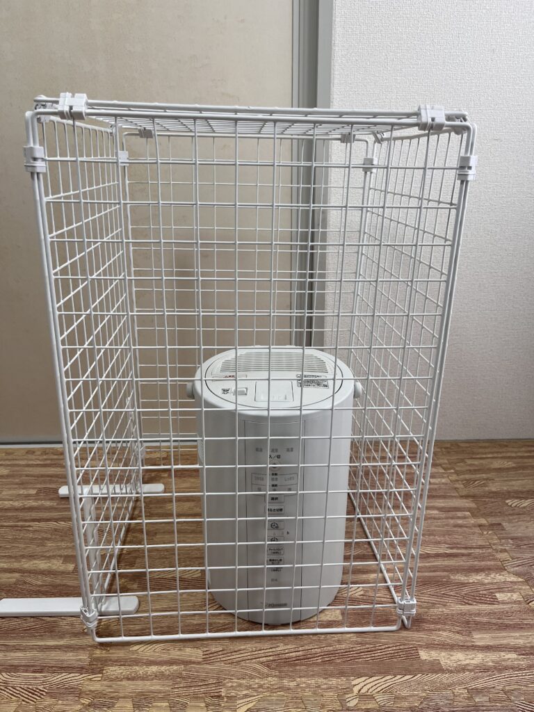 ダイソーのワイヤーネットで作ったガードの中に象印EE-DC35加湿器を入れて使っている様子