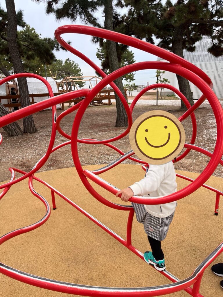 須磨シーワールドの海沿いエリアで、赤い遊具に登って遊ぶ子ども。