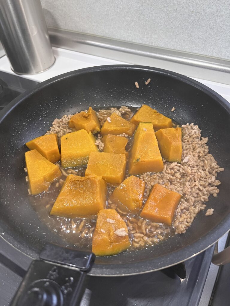 フライパンでかぼちゃとミンチを煮ている様子