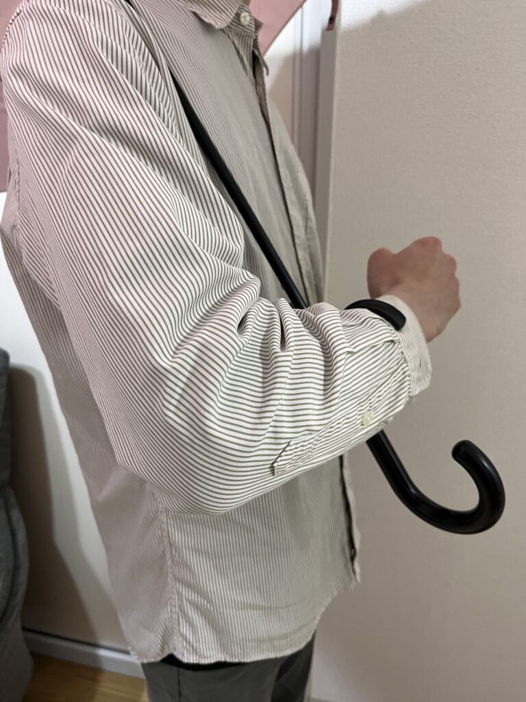 セリアの傘ホルダーを使って腕に傘を引っ掛けている様子
