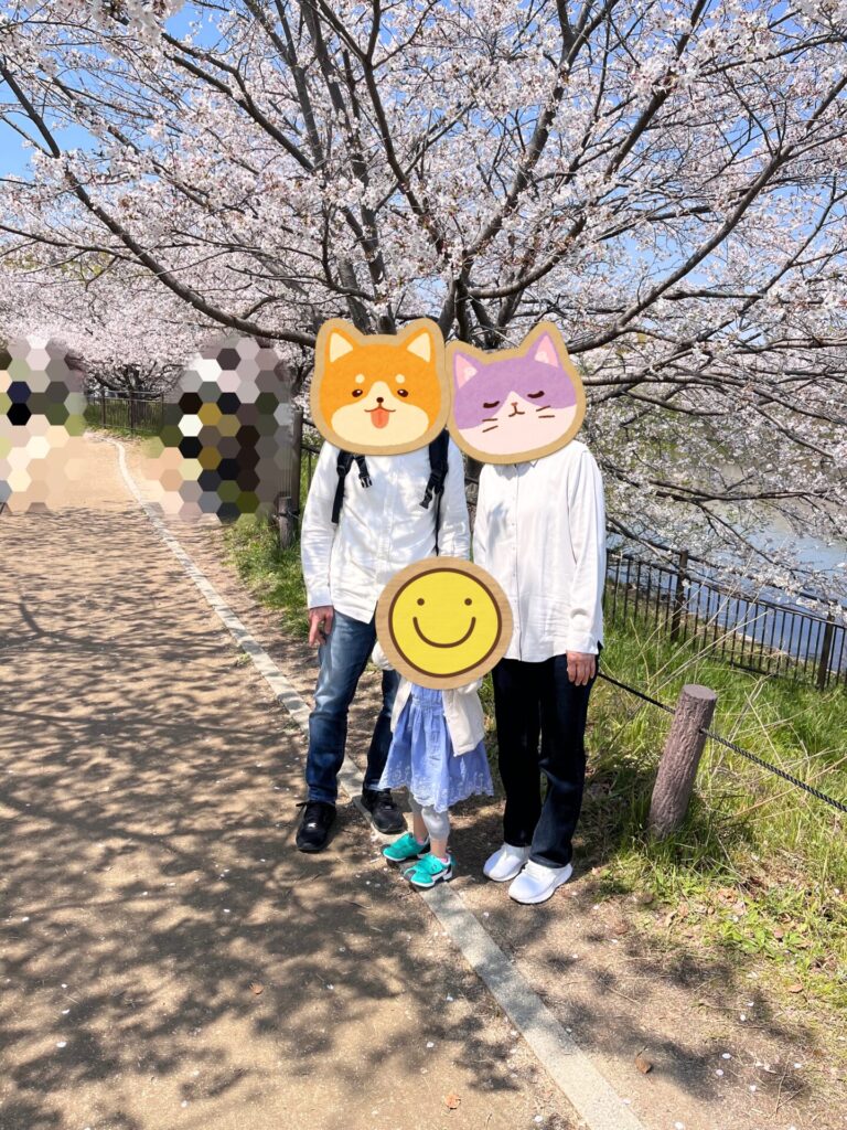 鶴見緑地の池沿いの桜並木で家族で写真を撮っている様子
