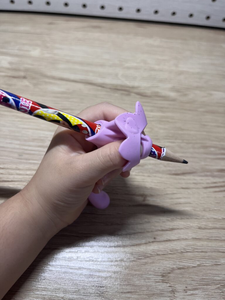 セリアのえんぴつの持ち方サポートグリップを使って左手で鉛筆を持つ3歳児の手元