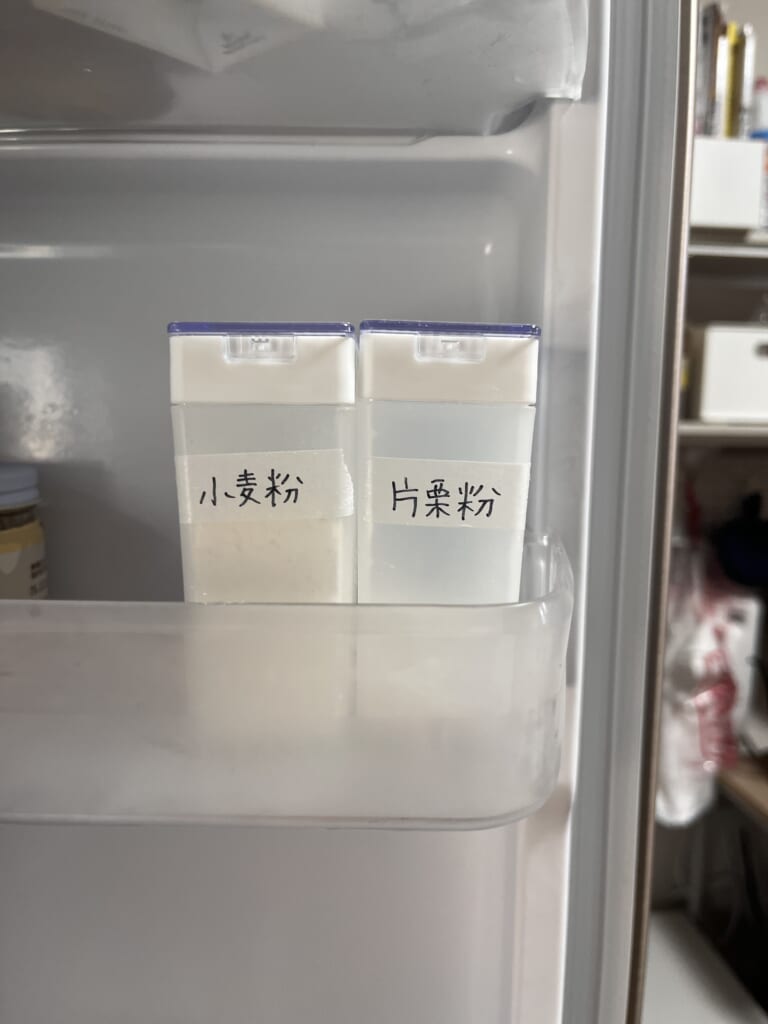冷蔵庫のドアポケットに並べた小麦粉と片栗粉の粉ふりボトル
