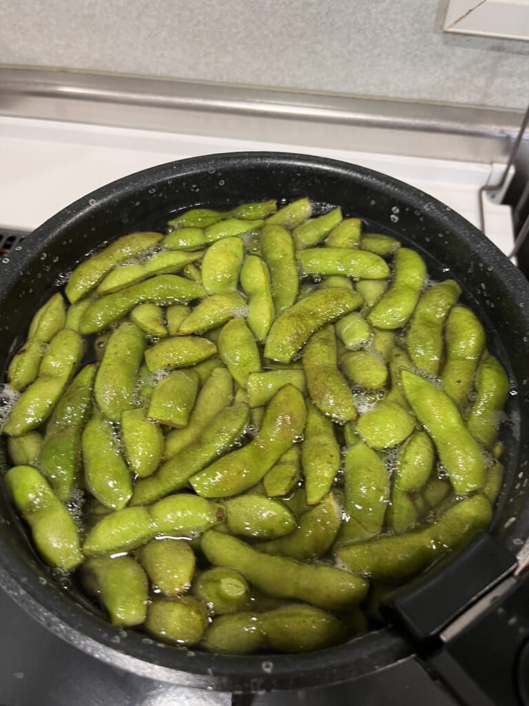 鍋でさや付きの枝豆を茹でている様子